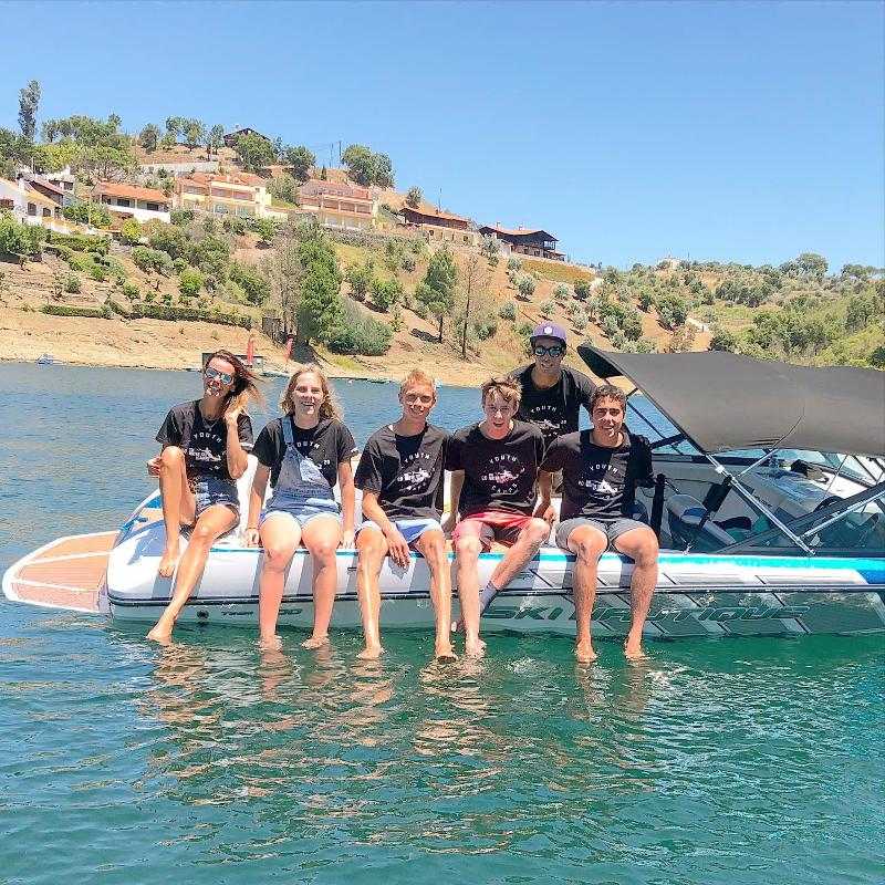 jovens mais monitores no barco no campo de férias aquático