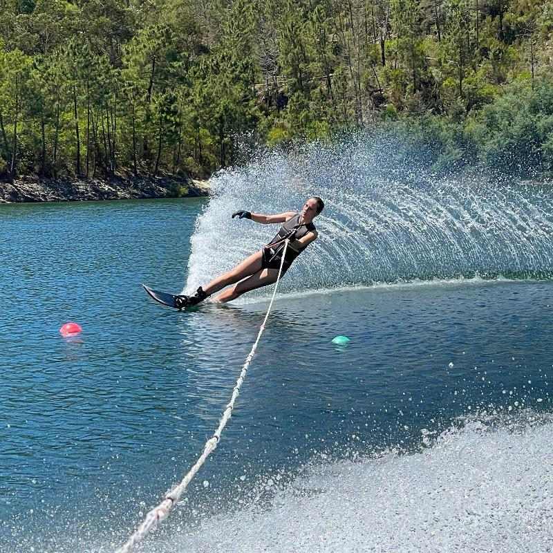 rapariga a fazer ski aquático no campo de férias desportos aquáticos