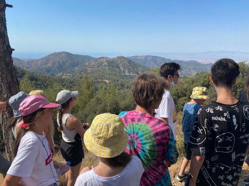  Vários jovens felizes a ver a natureza no topo de uma montanha durante o campo de férias Chipre. 