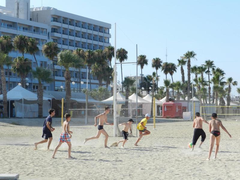 participantes a jogar à bola na praia no curso de inglês verão