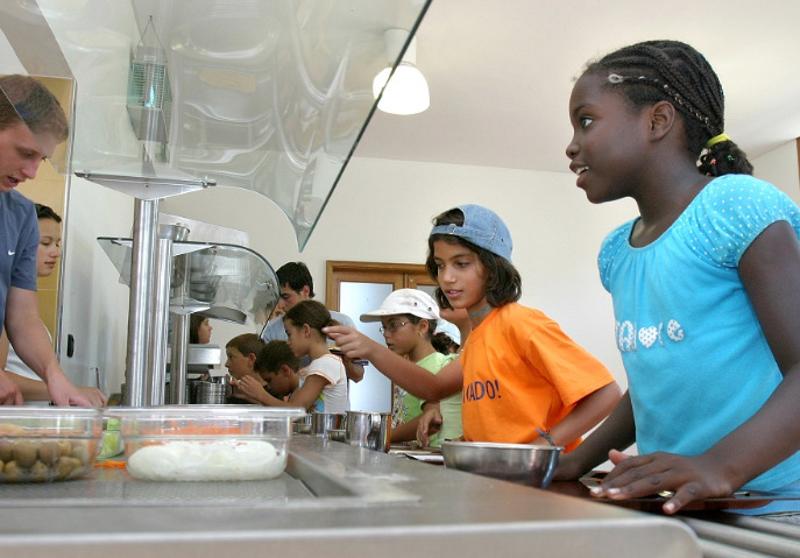 várias crianças na cantina do campo na fila para o almoço