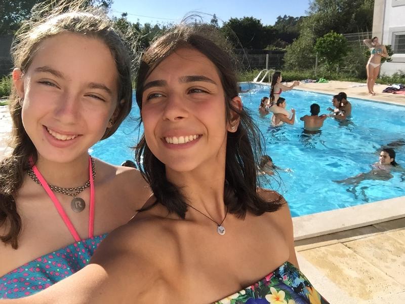 selfie de duas meninas participantes perto da piscina no surfcamp porto