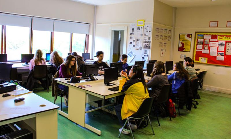 Grupo de jovens na sala de computadores durante as aulas do curso de línguas