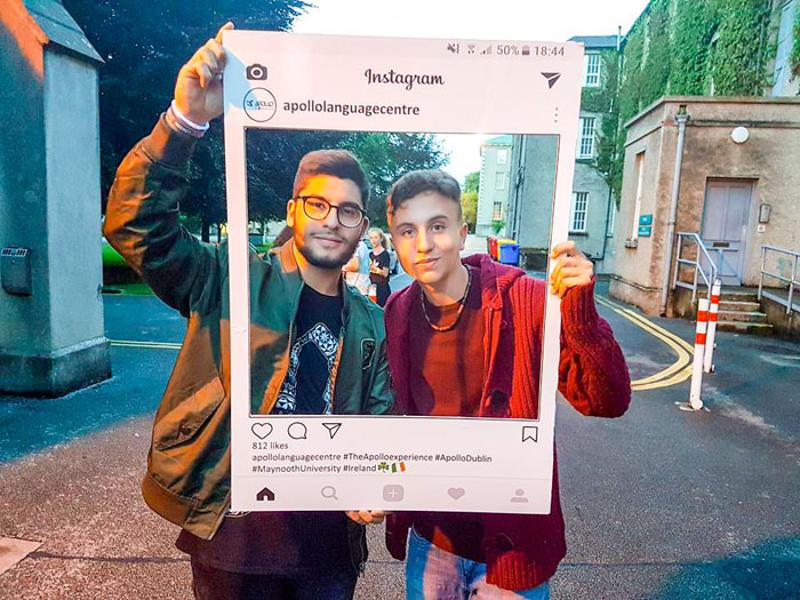 novos amigos a tirar foto com uma moldura de cartão nos cursos de línguas em Dublin