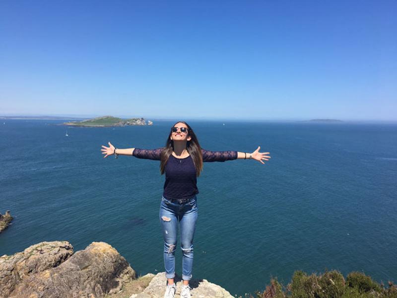participante de braços abertos com vista para o mar no curso de ingles em dublin