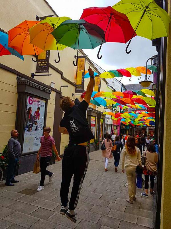 participante a tocar num guarda chuva decorativo numa rua na excursão do curso de inglês em dublin