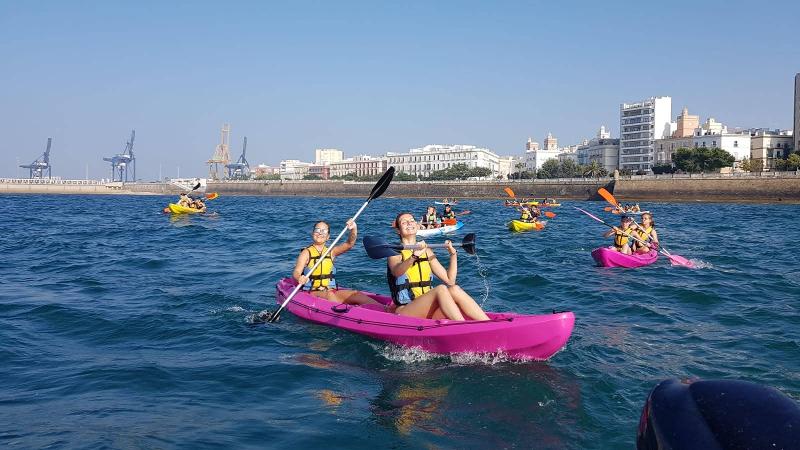 Alunos dos cursos de língua espanhola a praticar caiaque no mar, aproveitando uma atividade ao ar livre.