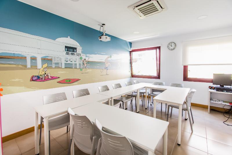 Sala de aula luminosa e moderna dos cursos de espanhol, decorada com um mural de praia.