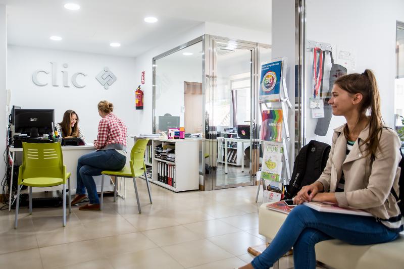 Receção dos cursos de espanhol com alunas a serem atendidas e a aguardar com materiais de estudo.