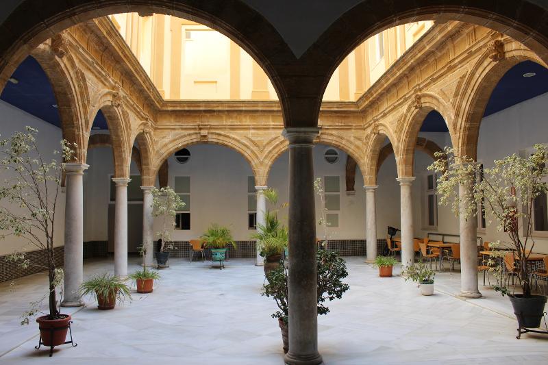 Pátio arejado com colunas clássicas e plantas, proporcionando um ambiente inspirador para estudantes que fazem cursos de línguas em Espanha.
