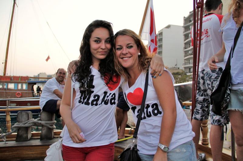 Duas raparigas com t-shirt a dizer "I love Malta", a disfrutar da marina de Malta durante os cursos de inglês em malta.