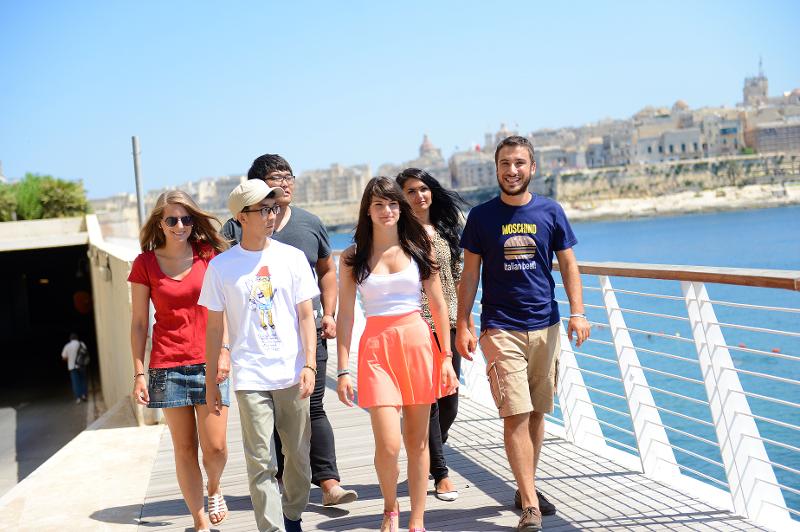 Participantes a andar ao longo do rio ao sol, aproveitando o tempo livre durante os cursos de inglês em malta.