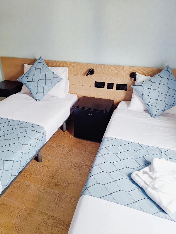 Quarto de 2 camas moderno no hotel, oferecendo conforto e praticidade durante os cursos de inglês em malta.