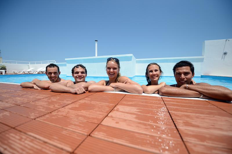 Participantes na piscina a sorrir e a posar para a foto, aproveitando o tempo livre durante os cursos de inglês em malta.