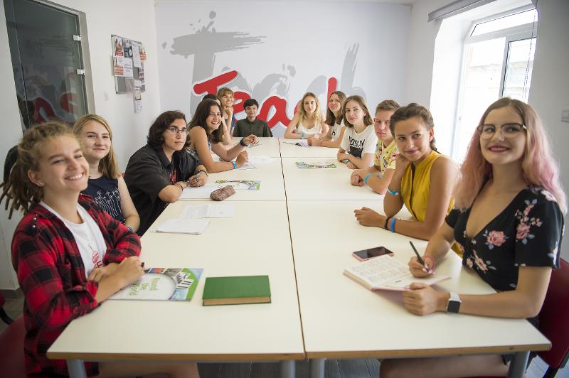 Estudantes sentados à mesa, concentrados durante as aulas dos cursos de inglês em malta.