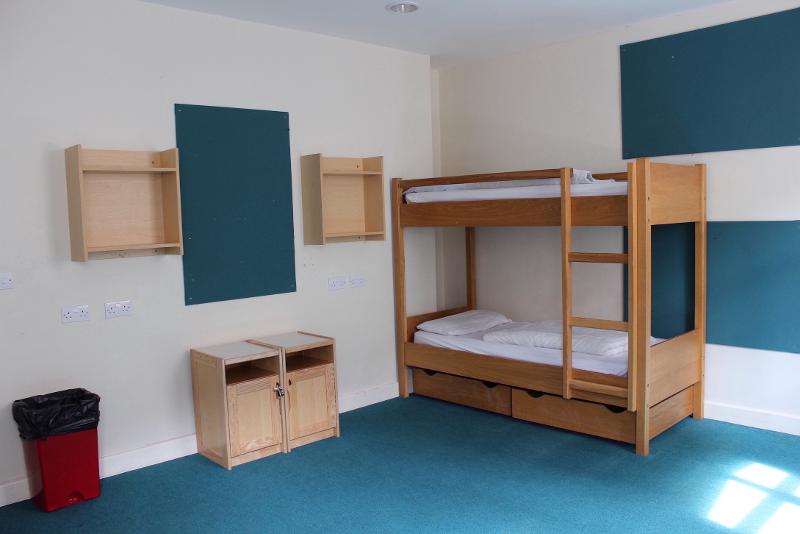 Quarto com beliche e mobiliário prático para participantes do curso de ingles para jovens.
