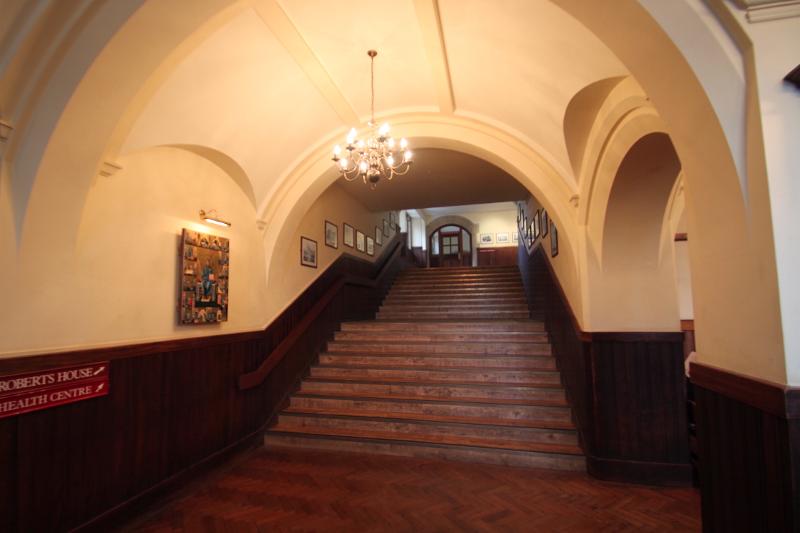 Entrada principal com escadaria imponente em um edifício histórico, parte das instalações do curso de ingles para jovens.
