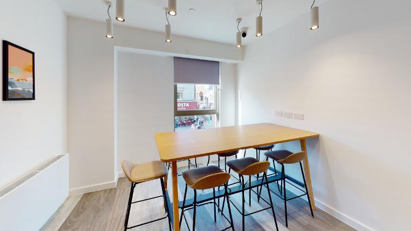 Sala ampla com luz natural e espaço para refeições durante o curso de ingles para jovens