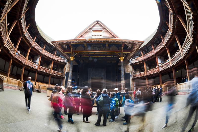 Grupo de estudantes em visita a um teatro histórico ao ar livre, parte de um curso de ingles para jovens.