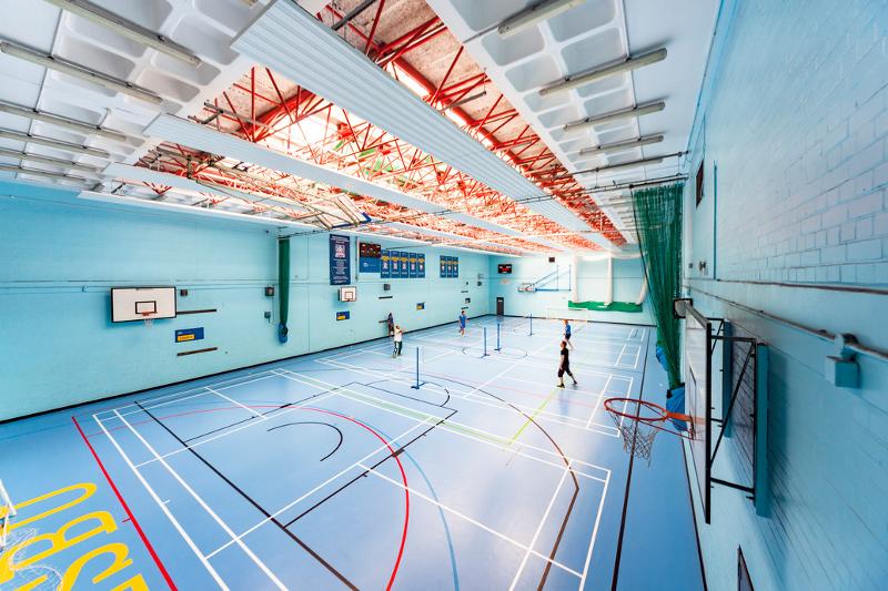Ginásio amplo com várias quadras desportivas, disponível para atividades durante um curso de ingles para jovens.