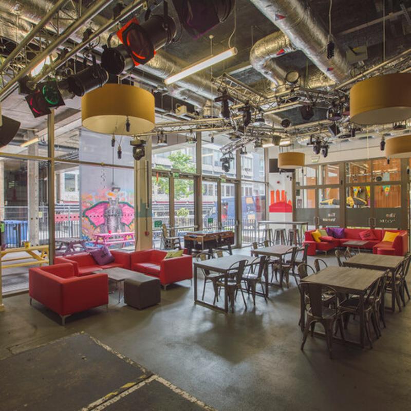 Espaço social vibrante no centro Kings, ideal para relaxar e socializar após as aulas do curso de língua inglesa, com áreas confortáveis e uma atmosfera animada.