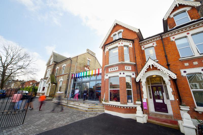 Edifício colorido e vibrante do centro de línguas, onde se realiza o curso de lingua inglesa, rodeado por um ambiente acolhedor.