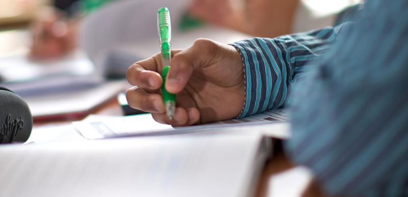 Estudante a escrever durante as aulas do curso de ingles para jovens