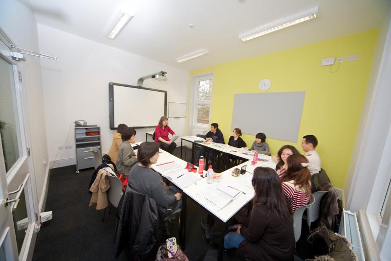 Sala de aula com vários participantes e a professora durante o curso de lingua inglesa