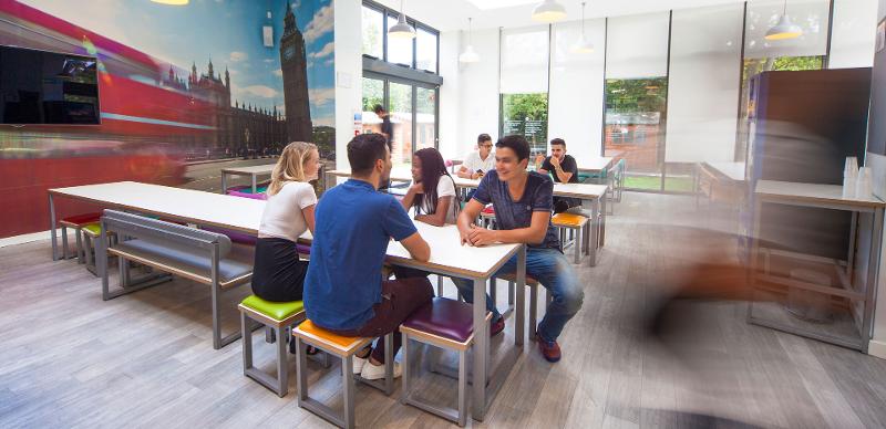 Sala de estudo do curso de lingua inglesa, onde alguns participantes estão sentados a rir e a conviver