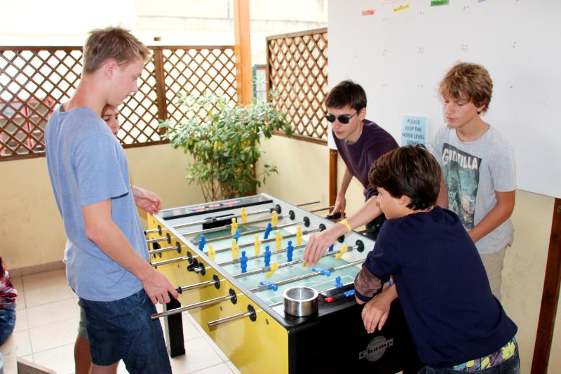 Grupo de jovens a jogar matraquilhos durante uma pausa no curso de ingles em malta, promovendo momentos de descontração e socialização.