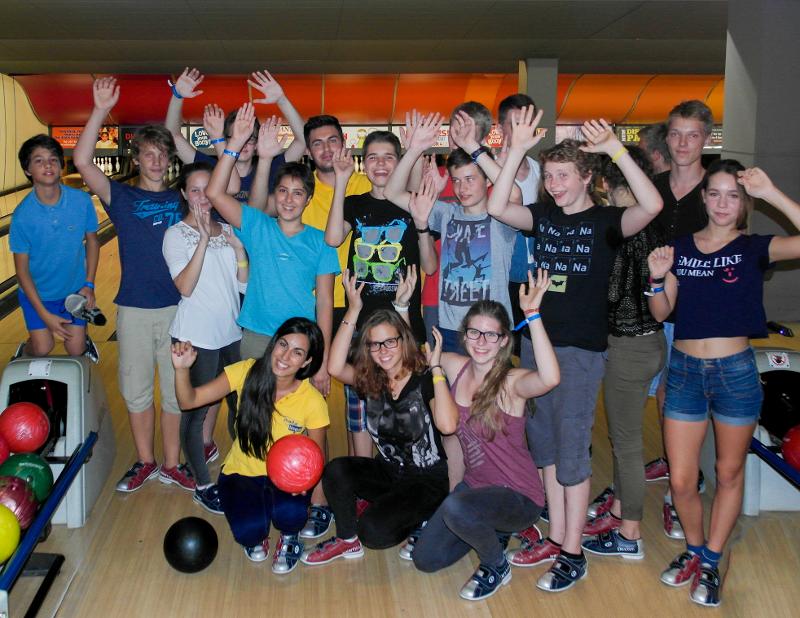 Grupo de estudantes a celebrar num jogo de bowling como parte de atividades sociais durante um curso de ingles em malta.
