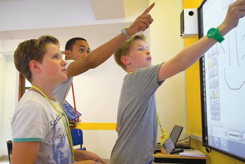 ovens estudantes interagem com um quadro interativo durante um curso de ingles em malta, participando numa atividade educativa.