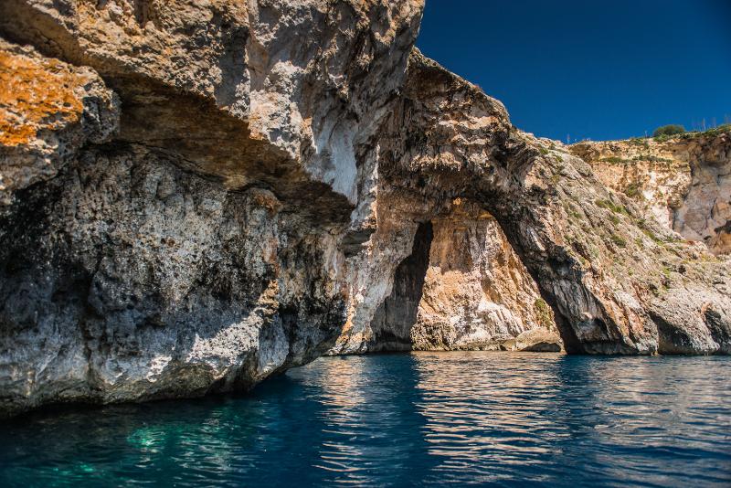 Arco rochoso natural sobre águas cristalinas em malta, cenário ideal para atividades ao ar livre durante um curso de linguas.