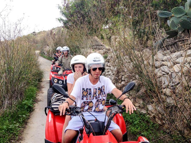 Grupo de jovens em motos-quatro a explorar caminhos rurais como parte de atividades de um curso de linguas em malta.