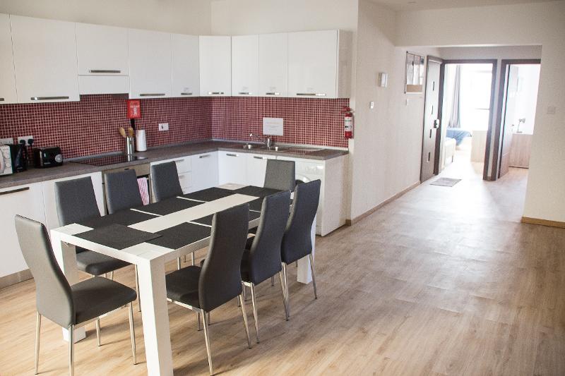 Cozinha moderna e espaçosa com mesa de jantar para estudantes de um curso de linguas em malta, proporcionando um espaço confortável para refeições e convivência.