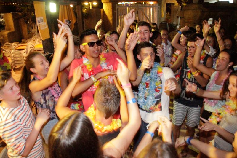 Grupo de jovens a dançar e a divertir-se numa festa temática durante um curso de linguas em malta.