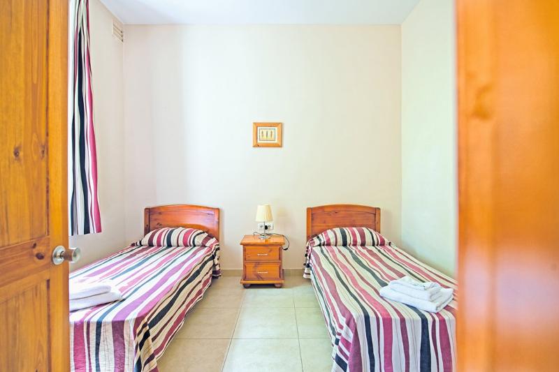 Quarto simples com camas separadas e decoração colorida, proporcionando conforto durante um curso de ingles na alemanha.