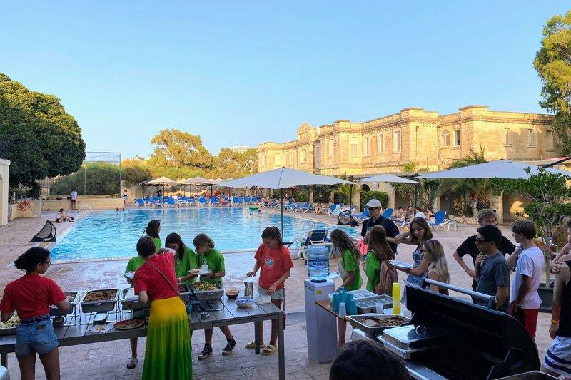 Estudantes aproveitam o tempo livre durante o curso de linguas para socializar à beira da piscina.