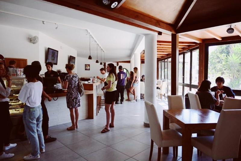 Estudantes interagindo num café moderno e descontraído, onde estão desfrutando de um momento de lazer após o curso de ingles na alemanha.