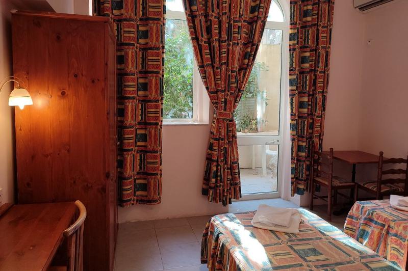 Quarto simples com camas confortáveis e janelas que deixam entrar luz natural, perfeito para relaxar durante o teu curso de linguas na alemanha. Ambiente acolhedor para uma estadia tranquila.