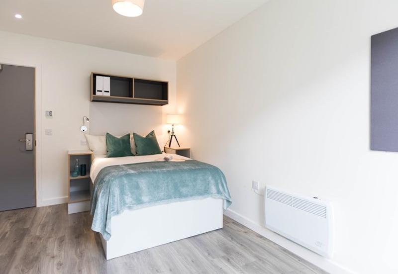 Quarto moderno e acolhedor com cama de casal, disponível para participantes do curso de ingles cambridge, proporcionando conforto durante a estadia.
