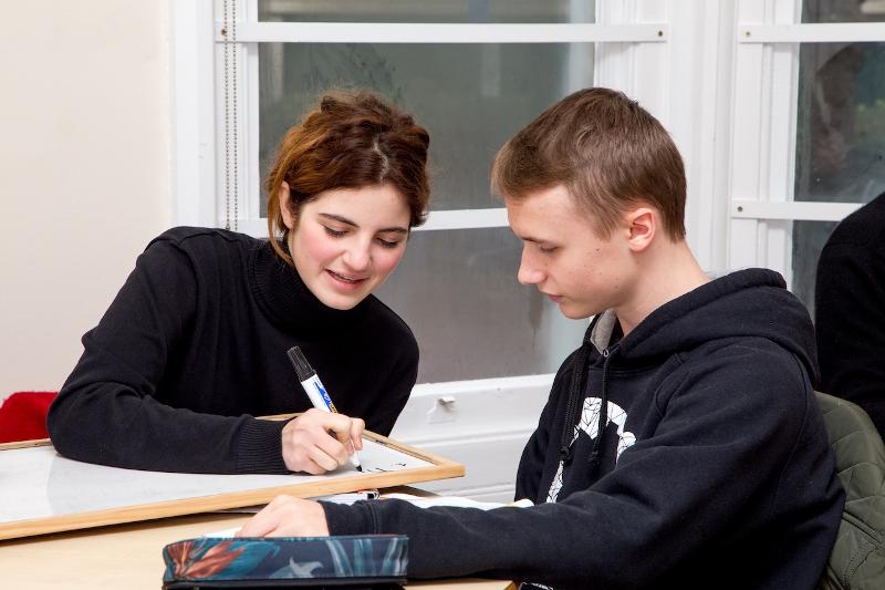 Dois participantes concentram-se em desenvolver um projeto de aula juntos do curso de línguas