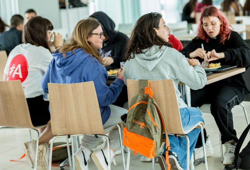 Grupo de estudantes a socializar e a fazer refeições juntos, aproveitando o convívio durante o curso de língua inglesa.