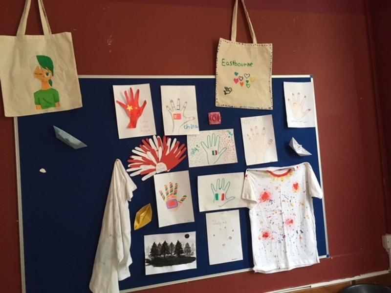 Quadro de exposição com trabalhos artísticos de estudantes, incluindo desenhos de mãos e outros projetos, no curso de língua inglesa.