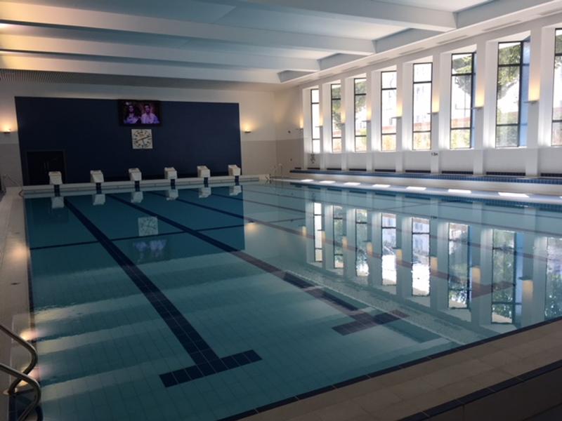 Piscina interior moderna e iluminada, pronta para atividades recreativas e desportivas durante o curso de língua inglesa.