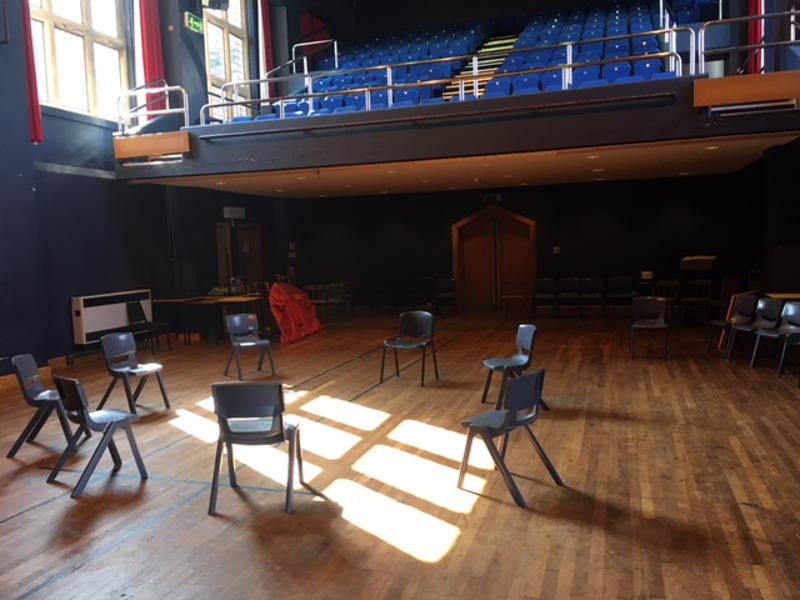 Sala de teatro com cadeiras dispostas em círculo, preparada para atividades interativas do curso de inglês no Reino Unido.