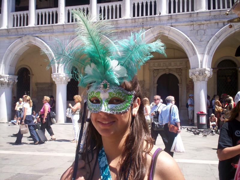 Jovem com máscara de carnaval em Veneza, imersa na cultura durante um curso italiano.