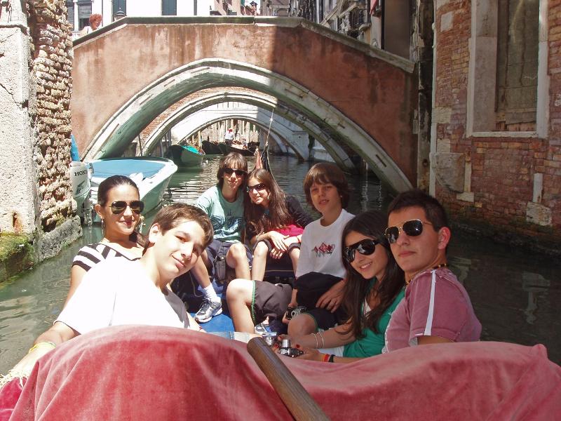 Grupo de jovens a desfrutar de um passeio de gôndola pelos canais de Veneza durante um curso italiano.