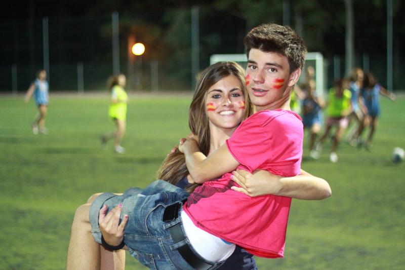 Dois jovens a divertir-se durante uma atividade desportiva ao ar livre como parte de um curso italiano.