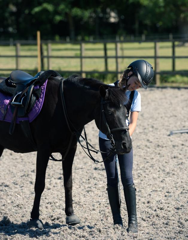 participante e cavalo preto no final da atividade de equitação no curso de línguas na Escócia